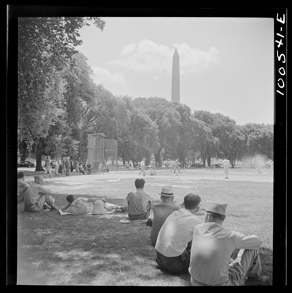 A crowd stands around a baseball diamond at the Ellipse in Washington, D.C., while a game is underway in July 1942.